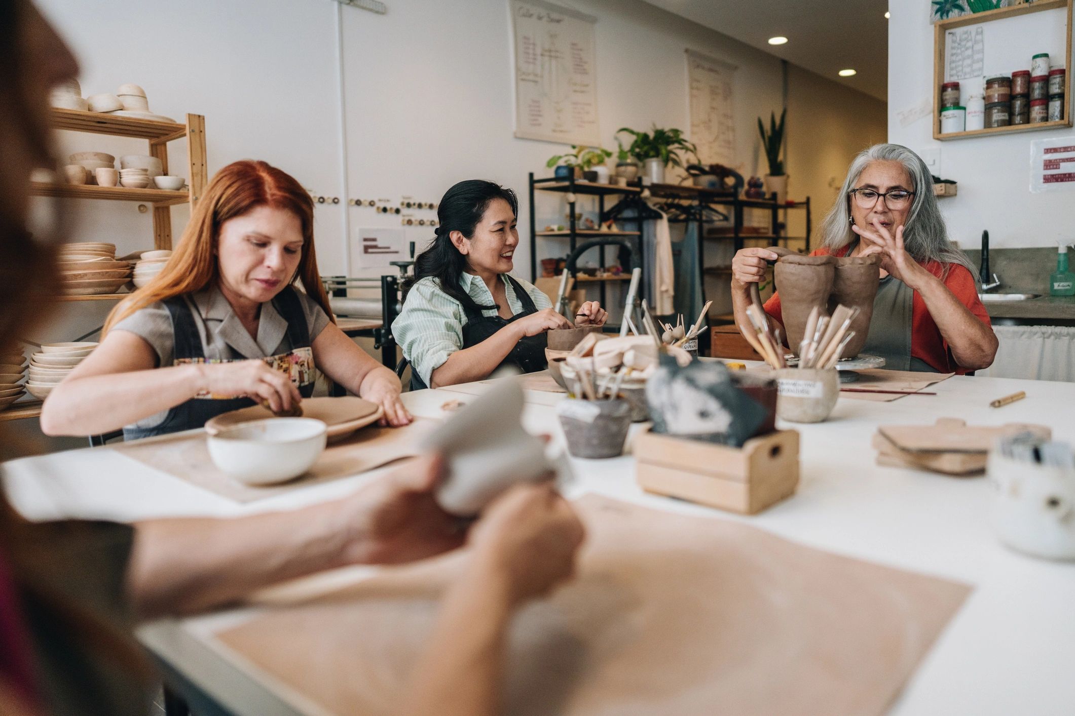 Friends participating in a pottery workshop together
